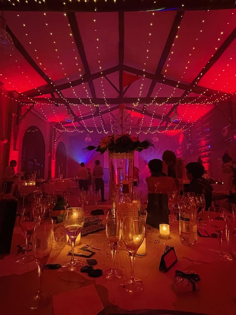 Salle de mariage baignée de rouge par des pars LED, éclairage architectural installé par PADJ
