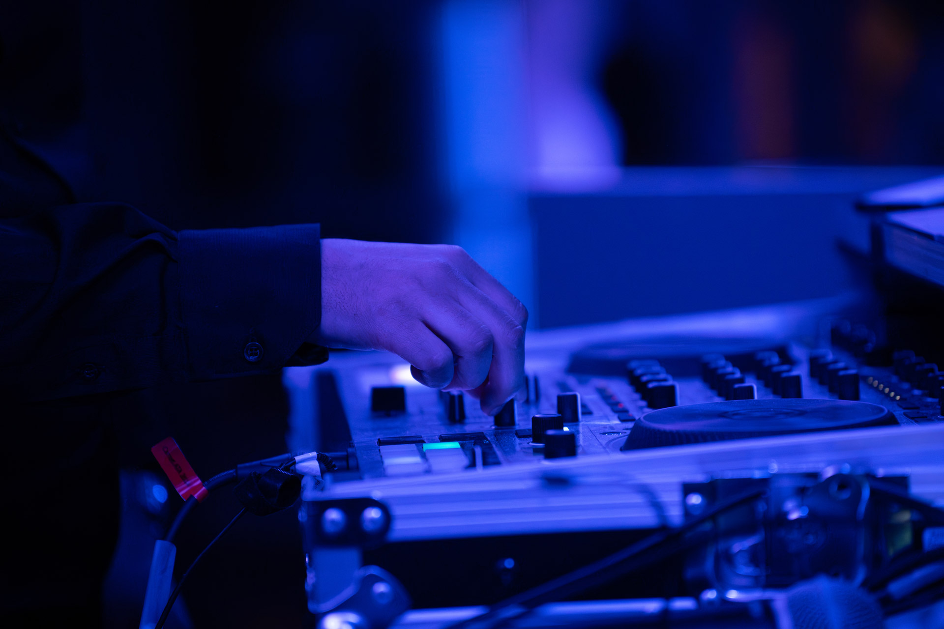 Close-up of hands on the Traktor Kontrol S4 MK3 controller during a wedding