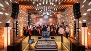 DJ mariage à Toulouse : piste de danse pleine dans un château en pierre, invités bras levés, boule à facettes et éclairage PADJ